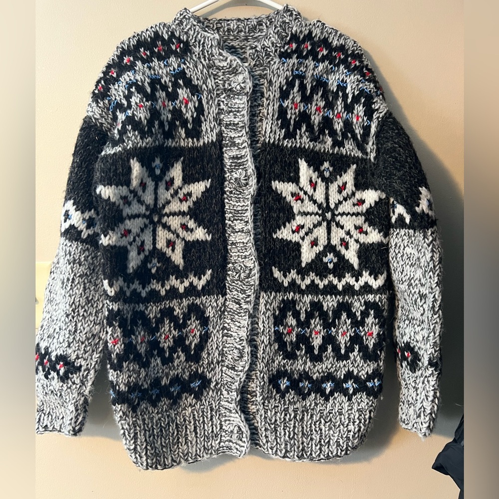 Hand knit button up cardigan. Black white blue and red Nordic snowflake pattern.